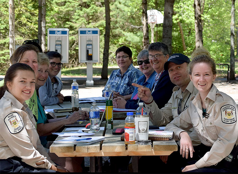 photo of group of volunteer sitting at picnic table