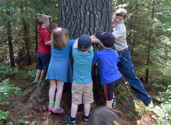 photo of children and park staff hugging a tree